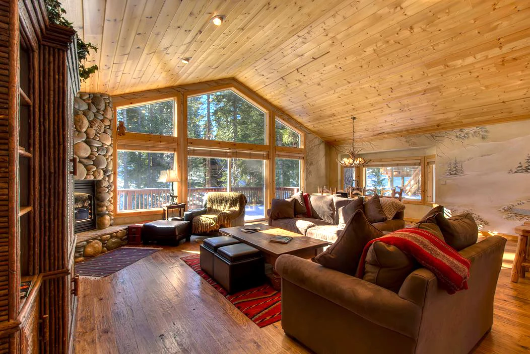 Warm timber living space with tall windows and a vaulted ceiling